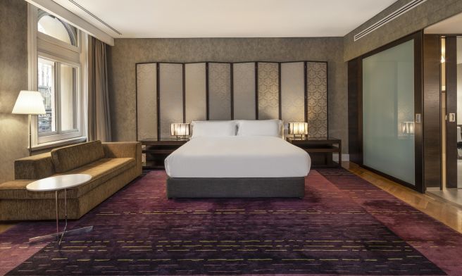 A bedroom in InterContinental Melbourne, featuring a king-sized bed with white linens